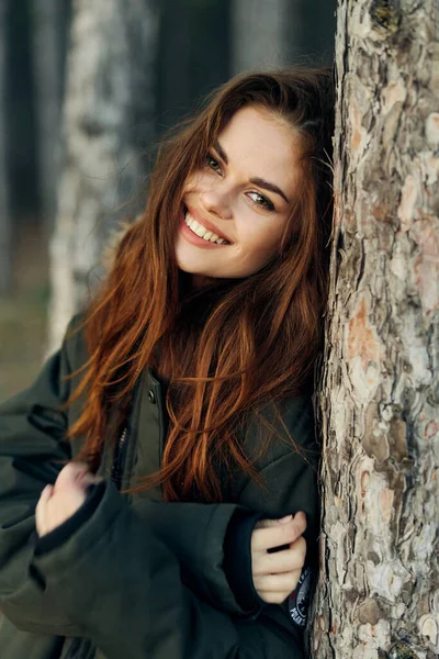 在森林度假生活中穿着保暖外套微笑的女人 — 图库照片