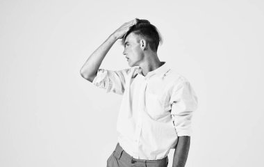 Gömlek ve pantolon giyen yakışıklı adam elleriyle el kol hareketi yapıyor. Saç modeli.