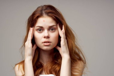 Gri arka planda kızıl saçlı güzel bir kadının portresi.