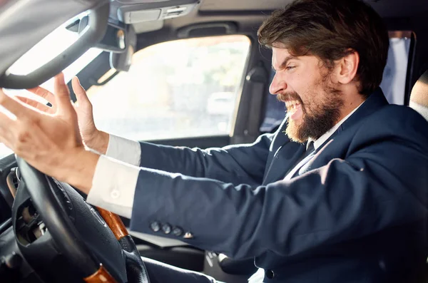 Emotional man driving a car gesturing with his hands road track — Stock Photo, Image