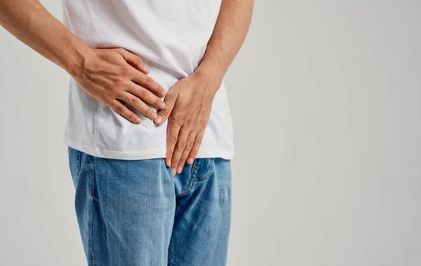Hombre experimentando dolor debajo del cinturón en la ingle y jeans modelo camiseta — Foto de Stock