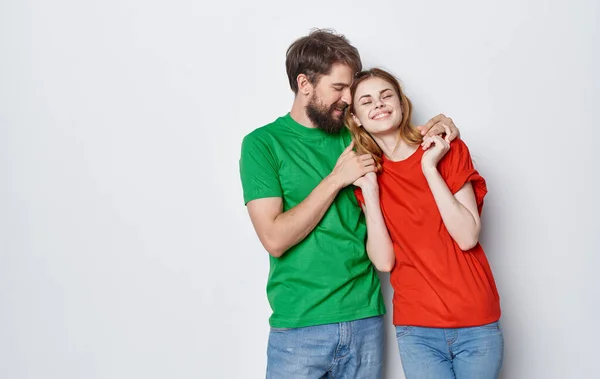 Jovem casal alegre em multicoloridas t-shirts comunicação emoções estúdio amizade — Fotografia de Stock