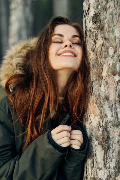 靠在最近闭上的眼睛上的女人笑着呼吸着新鲜的空气秋天的森林 — 图库照片