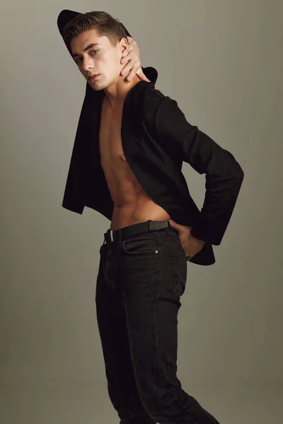 年轻帅小伙时髦的发式黑色夹克装扮自信米色背景 — 图库照片