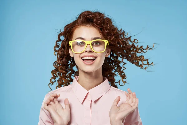 Frau mit lockigem Haar und gelb rosa Hemd blauer Hintergrund — Stockfoto