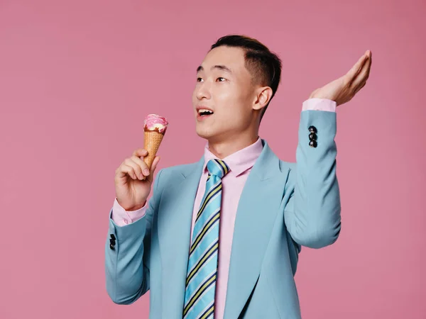 Aranyos férfi kék öltöny fagylalt öröm szórakozás rózsaszín háttér — Stock Fotó