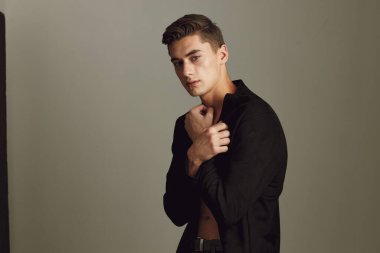 Sevimli genç adam ve şık saç stili siyah gömlek kendine güven.