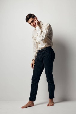 Büyümüş bir adam Aydınlık bir odada beyaz gömlekli, siyah pantolonlu 