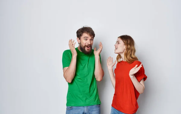 Jeune couple gai en t-shirts multicolores communication émotions amitié studio — Photo