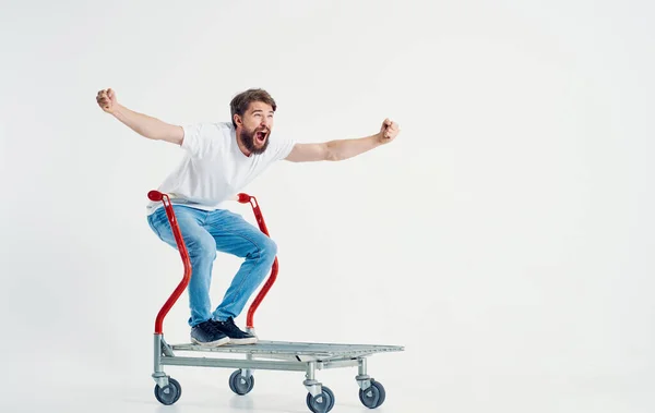 Hombre alegre monta en un carro de carga en una habitación brillante — Foto de Stock
