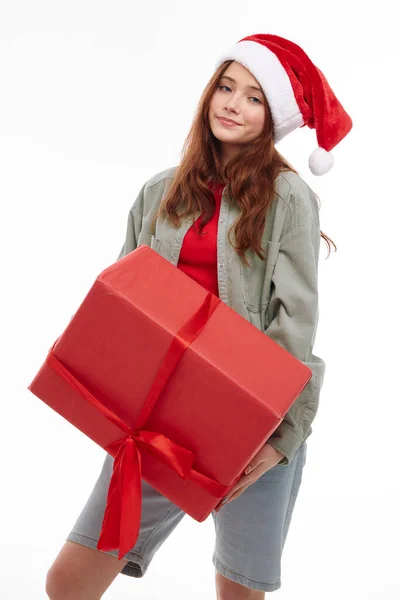 Дівчина з великим червоним подарунком в руках Різдвяний капелюх Різдвяна студія — стокове фото
