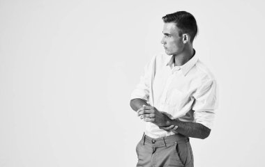 Pantolon ve gömlek giymiş yakışıklı bir adam. Elleri önde, portresi önde.