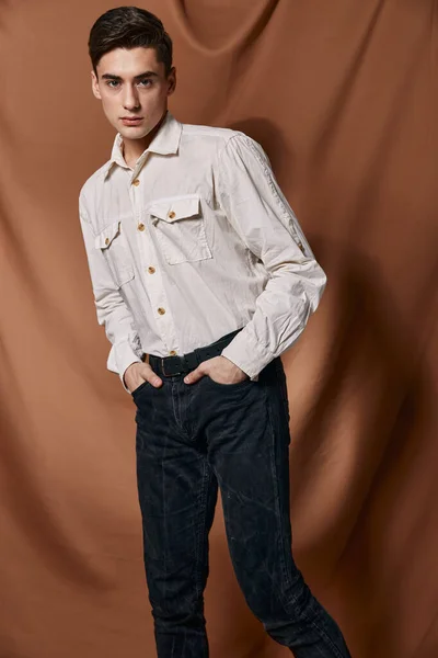 Knappe man wit shirt moderne stijl zelfvertrouwen handen in zakken — Stockfoto