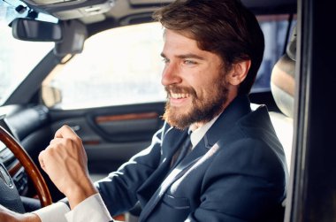 Takım elbiseli neşeli iş adamı bir araba gezisi yolcu yolunda