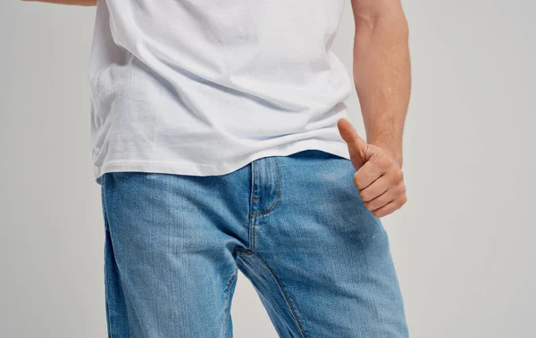 Un homme en jean et un t-shirt montre un pouce sous la ceinture — Photo