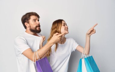 Neşeli genç çift tişörtü kotları mağazadan alışveriş yapıyor.