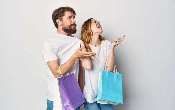 Alegre joven pareja camiseta jeans emociones alegría compras en la tienda — Foto de Stock