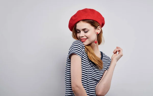 Mulher bonita em um listrado gestos de t-shirt com as mãos em um fundo leve Copiar espaço corte vista modelo — Fotografia de Stock