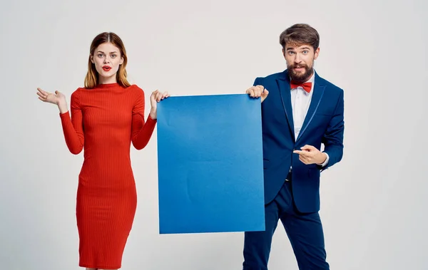 Femme en robe rouge homme élégant en costume avec feuille bleue de papier dans les mains de l'agence de publicité — Photo