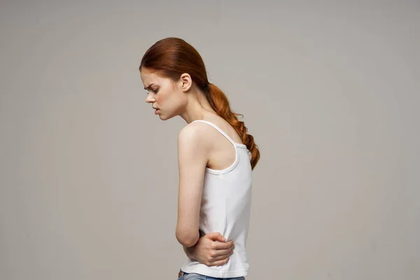 Mujer en camiseta blanca sosteniendo su vientre problemas de salud menstruación ginecología —  Fotos de Stock