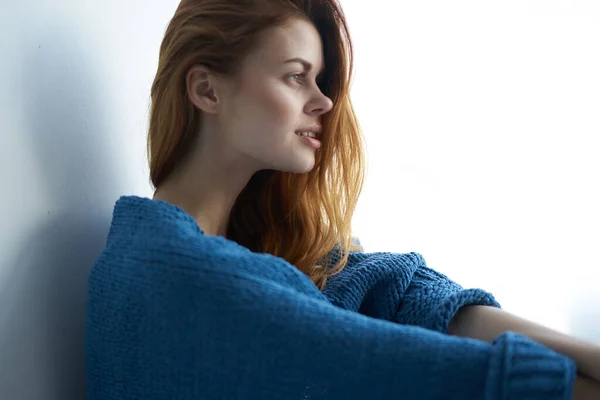 Mooie vrouw in blauwe ruit zit op de vensterbank interieur charme — Stockfoto