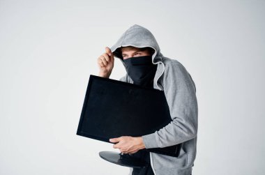 Kapüşonlu maskeli adam teknisyen hacker işaretlemesini çalıyor.