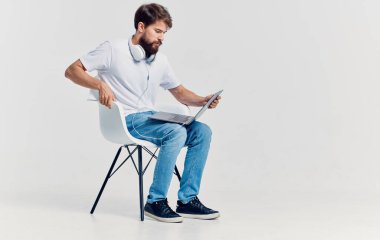 Kulaklıkla dizüstü bilgisayarın önünde oturan adam iletişim teknolojisi arka planda izole edilmiş.