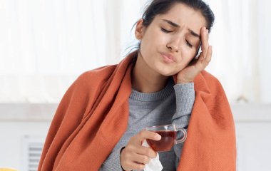 Bir fincan sıcak içeceği olan kadın sağlık sorunları burnu akan portakal rengi ekose.