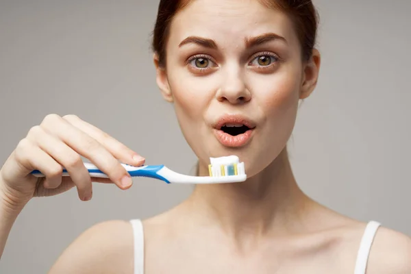 Woman holding a toothbrush with paste in her hands dental care hygiene close-up — Stock Photo, Image