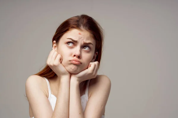 Emotionell kvinna som har akne i ansiktet på en grå bakgrund hälsoproblem — Stockfoto