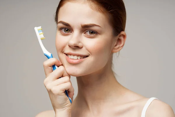 Mulher em branco t-shirt escova de dentes sorriso saúde e higiene — Fotografia de Stock