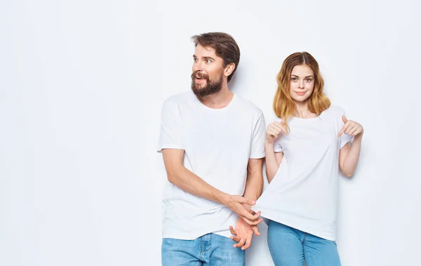 Muž a žena v identické trička na lehkém pozadí džíny rodina módní styl — Stock fotografie