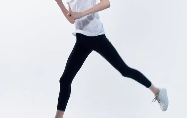 Енергійна спортсменка біжить по світлому фону у кросівках і переглядає Copy Space — стокове фото