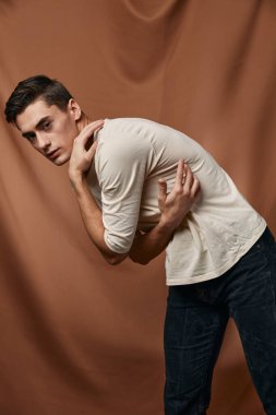 Şirin beyaz bluz, stüdyo kumaşı, kahverengi arka plan modeli.