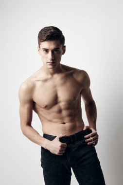 Mide sporu figürü pantolon modelinde çıplak gövde küpleri olan adam.