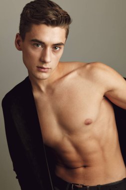 Bej arka planda çıplak omuzlu çekici bir beyefendi. 