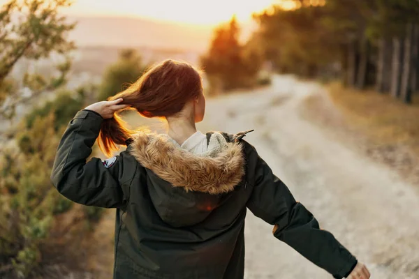 Mujer sosteniendo el cabello en la naturaleza camino senderismo aire fresco —  Fotos de Stock