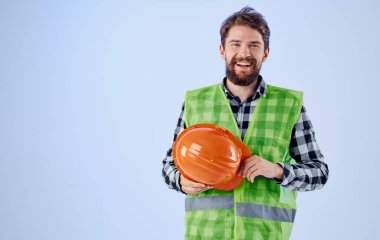 Elinde turuncu başlık ve yansıtıcı yelek olan bina mavi arkaplan kopyalama alanı