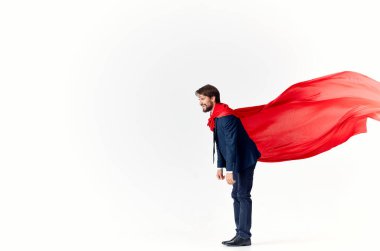 Kırmızı pelerinli bir iş adamı arka planda el hareketleriyle başarılı bir reklam uçuşu yapıyor.