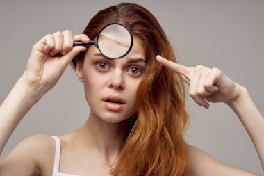 Yüzünde büyüteç olan kadın pencere sivilceleri sağlık sorunları yaşıyor.