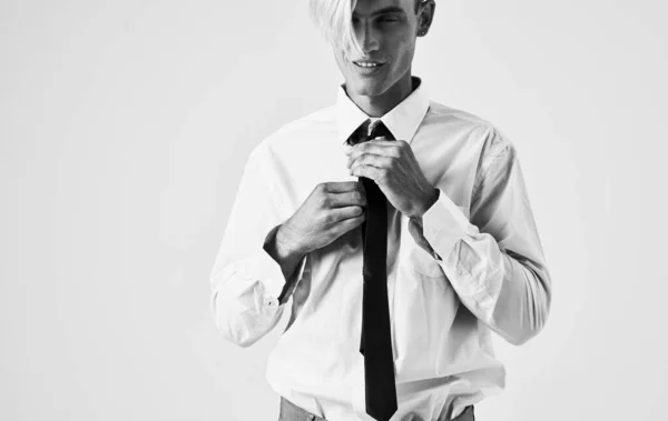 Elegant ung man i skjorta och slips på en ljus bakgrund beskärd vy porträtt närbild — Stockfoto