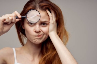 Yüzü sivilceli büyüteçli kadın sağlık sorunları dermatoloji ve kozmetoloji