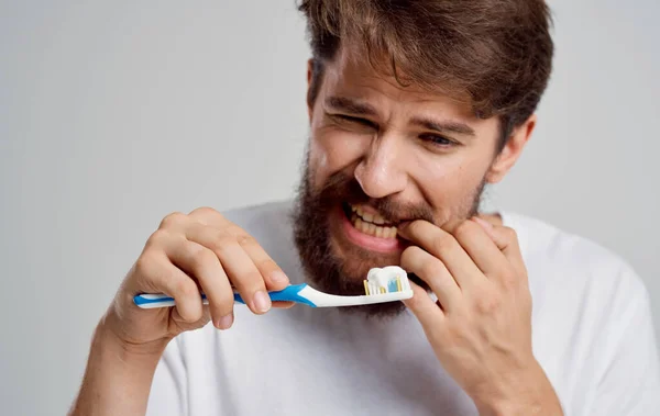 Muž s kartáčkem gesta s rukama bolest v ústní dutině ranní procedury — Stock fotografie