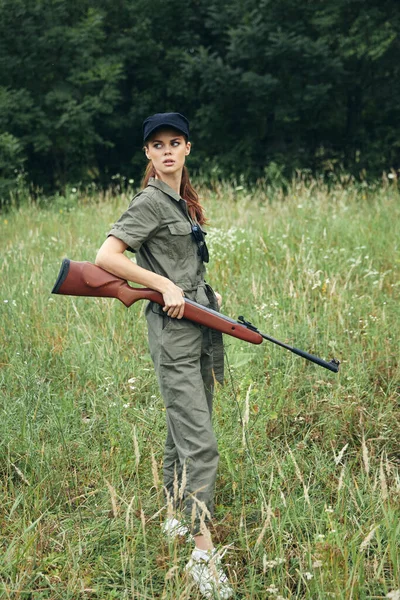 녹색 점프수트를 입고 양손에 무기를 든 여자 군인 — 스톡 사진