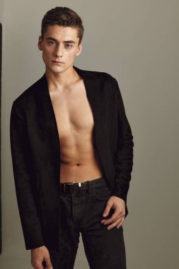 Yakışıklı, siyah gömlekli, düğmeleri iliklenmemiş çekici bir tip.