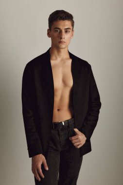 Siyah düğmesiz ceketli yakışıklı. Çekici. Lüks stüdyo modelleri.