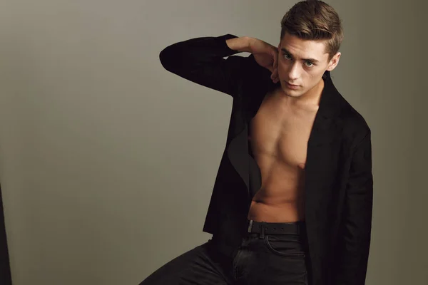 guy with unbuttoned black shirt fashion hairstyle posing studio self-confidence
