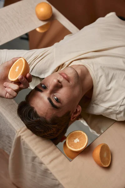 Handsome man fashionable hairstyle oranges mirror on the table