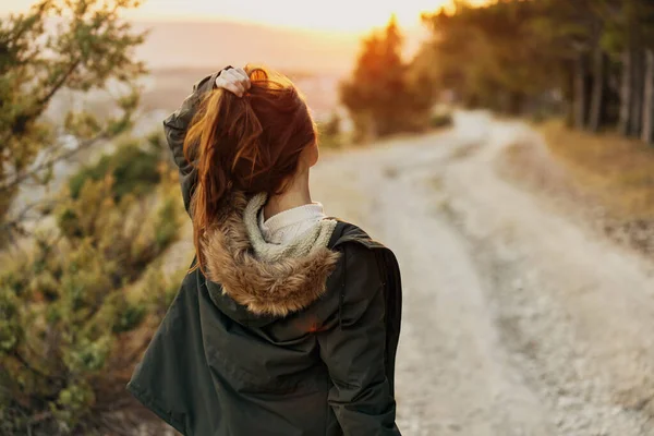 Mujer en una chaqueta sostiene su cabello naturaleza caminar estilo de vida día de ocio —  Fotos de Stock