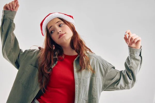Дівчина в різдвяному капелюсі танцює на світлому фоні веселі канікули — стокове фото